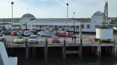 Robin Webster A view of the Ryde Pier Head car park from a passing ferry with a white train station building in the background