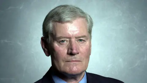 Former Coventry South MP Jim Cunningham formal portrait picture. He has grey hair, parted on the left side.