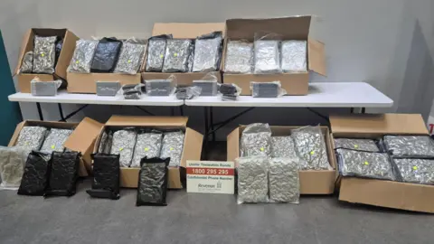 Approximately 80.5kg of cannabis and 5kg of cocaine all in black and see through bags in brown boxes.