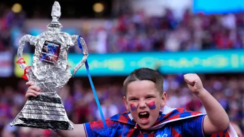 Reuters A young fan with his homemade FA Cup in the crowd