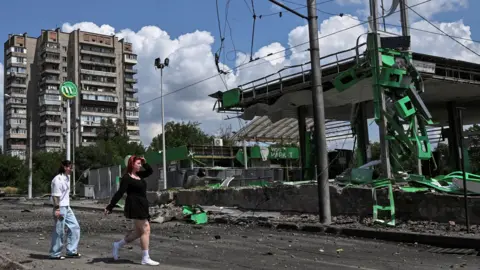 Reuters Residents walk at the site of a petrol station hit by a Russian airstrike, amid Russia's attack on Ukraine, in Zaporizhzhia, Ukraine July 26, 2026.