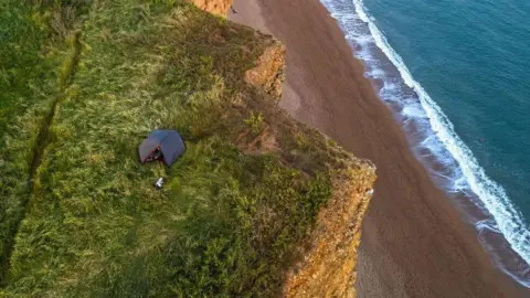 West Bay Photography Drone image of tent on clifftop