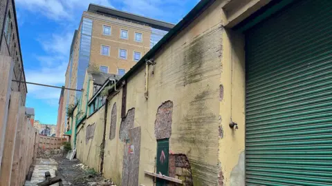 Dilapidated buildings at the site of the Stephenson Works. Several sections of plasterwork have fallen to the ground.