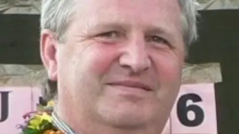 PTN Headshot of Howard Green. He has silver hair and is wearing a striped shirt.