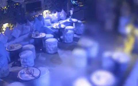 CPS Handout CCTV shows Vikas Nath using a straw to put gamma-butyrolactone (GBL) into a woman's spicy margarita drink while sitting in the rooftop garden bar