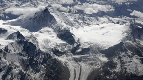 AFP via Getty Images An aerial photograph taken from a passenger aircraft shows snow-covered mountain peaks in Ladakh.