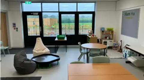 Inside a specially-adapted classroom at Hill View. There are bean bags on the floor and tables and chairs.