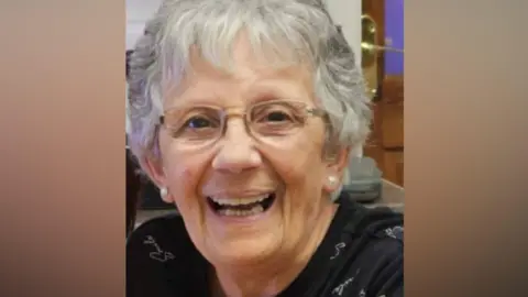 Margaret Quilliam Margaret Quilliam smiling, she has short grey hair and is wearing glasses.