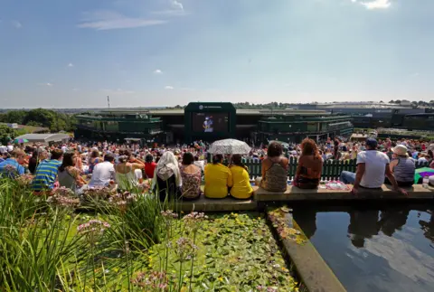 PA Media Taken at the top of Henman Hill thousands of fans are sitting in the sunshine watching tennis on the big screen outside Centre Court 