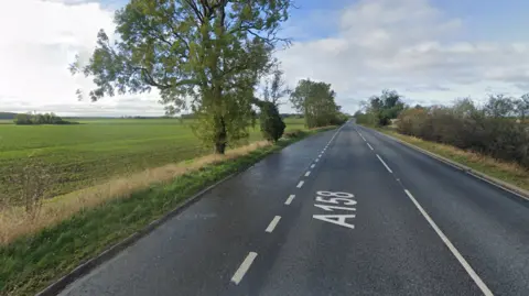 The A158 - a single carriageway road with flat, green fields on either side