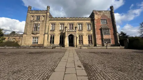 BBC Georgian style castle infront of pebbled grounds 