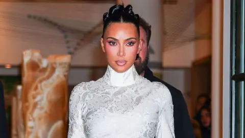 Getty Images US reality star Kim Kardashian in a white dress with long sleeves and turtle neck.