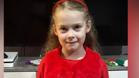 Amaya Davies wearing a red outfit and smiling