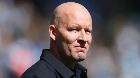 Henrik Pedersen looks into the distance wearing a navy blue jacket