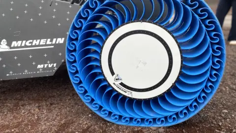 Padraig Belton Michelin's bright blue plastic wheel - curved spokes support a wide solid rim.