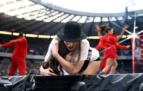 Getty Images Taylor Swift in Edinburgh, hugging a fan in the front row