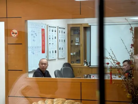 Joy Chiang / BBC Police officers inside the offices of Gold Apollo in Taipei. 