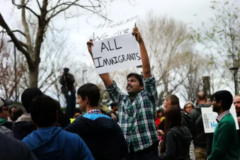 San Francisco Chronicle via Getty Images Muthumalla Dhandapani, an Indian immigrant with an H1-B visa and a Comcast employee in Sunnyvale, protests against President Trump's immigration orders in 2017. A bill in Congress would alter the employment-based immigrant system, tilting it towards immigrants from India and China, without increasing the overall number of visas for everyone. (Photo by Santiago Mejia/San Francisco Chronicle via Getty Images)