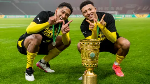 Jude Bellingham (left) and Jadon Sancho celebrate winning the German Cup with Borussia Dortmund in 2021