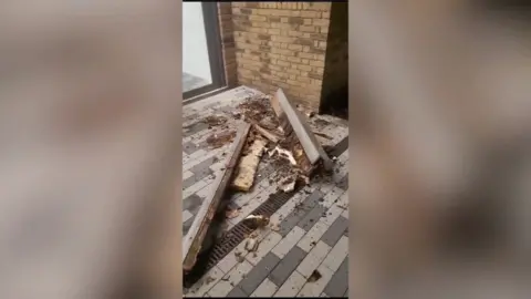 Piles of shattered wood and balcony fragments lie scattered on a private terrace, metres from the Surowka family's windows, where a mother and two children were sitting when the structure collapsed.