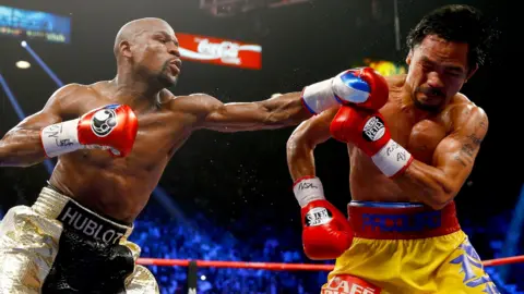 Floyd Mayweather throws a punch at Manny Pacquiao during their welterweight unification championship bout in May 2015 at MGM Grand Garden Arena in Las Vegas
