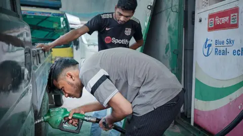 A man refuels a vehicle at a petrol station in Dhaka, Bangladesh, on Monday, March 9, 2026.