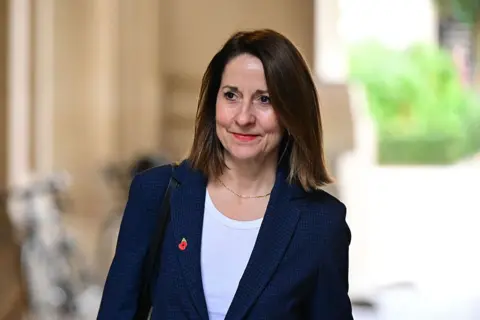 Getty A woman with dark hair in a blue suit and white T-shirt