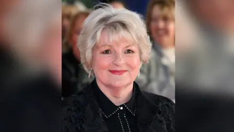 Getty Images A woman with short white blonde hair wearing a black shirt and jacket
