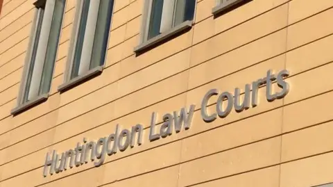 Brian Farmer/BBC The words 'Huntingdon Law Courts' written on the side of a cream building.