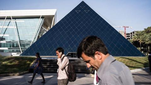 Infosys Ltd. employees walk past the K. Dinesh Communication Design Center at the company's campus in Electronics City in Bangalore, India, on Monday, Feb. 4, 2013. Infosys is India's No. 2 software exporter. Photographer: Sanjit Das/Bloomberg via Getty Images