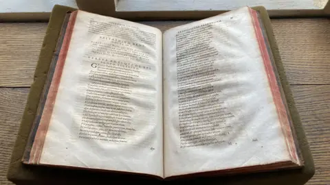 Master and Fellows of Sidney Sussex College An old book is open and sitting on a table. 