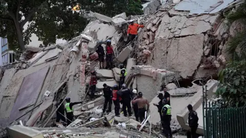 Rescuers search for victims in a collapsed building following an earthquake in Caracas on June 24, 2026.