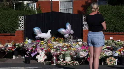 Reuters A woman looks at floral tributes and stuffed teddy bears, on the junction of Tithebarn Road and Hart Street