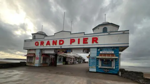 Picture of Weston 's Grand Pier with a moody grey sky behind.