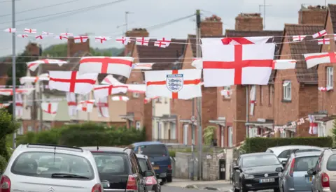 Getty Images A photo of Torrington Avenue, a residential street in Knowle West, Bristol from 2016. There are houses all along the street and cars parked on both sides of the road.