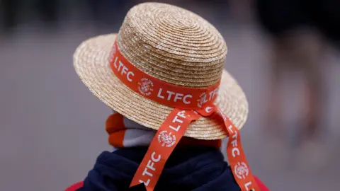  Reuters A Luton straw hat with orange football club branding