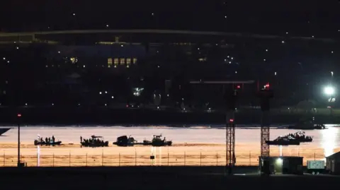 Reuters Rescue boats searching a river