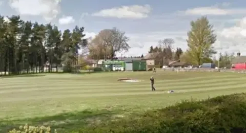 Google A golf course with a bunker and a golfer mid-swing