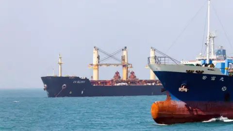 Two blue ships on a bright blue sea.