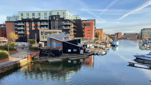 A view of Lincoln's Brayford Pool, showing One The Brayford alongside other buildings next to the water.  