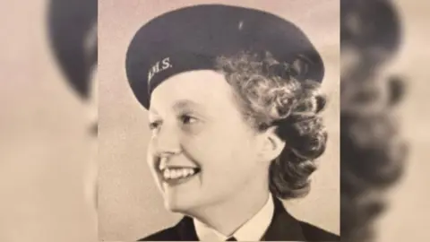 Supplied A sepia toned photo of a young Thelma in her naval uniform, and with a smile she is looking off to the left.