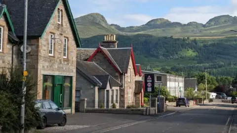 A street in a village with hills in the background
