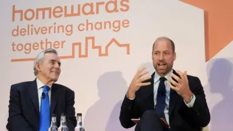 The Prince of Wales (right) and former Prime Minister and Multibank Founder Rt Hon Gordon Brown Left) on white chairs. Gordon Brown is laughing while Prince William speaks and gesticulates.