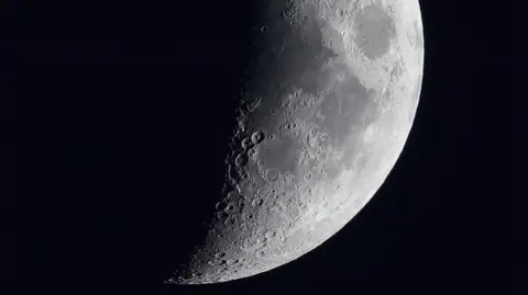 A quarter of the Moon, partly in shadow