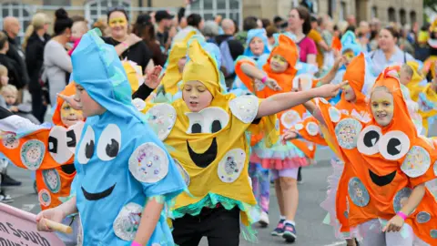 Stockton Borough Council Children dressed as colourful stars dance on the high street.