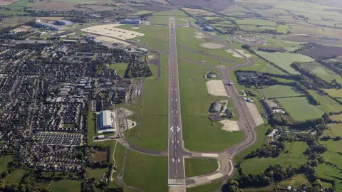 Getty Images An aerial view of RAF Brize Norton shows the full length of the main runway, taxiways and operational hardstanding, highlighting the scale of the airfield and its role as the UK's principal hub for strategic airlift, aerial refuelling and global military logistics, photographed from approximately 1,500 feet on September 25, 2025 in Oxfordshire, England.