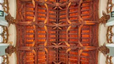 Mike Daines Looking up at St Wendreda's angel roof. At least 22 angels can be seen, either whole or in part. Some are attached to the ceiling beams and others are attached to the wall below the roof and beside the windows