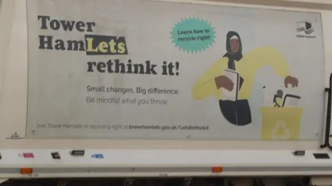 The side of the refuse lorry has a cartoon of a woman separating rubbish into recycling and no recycling