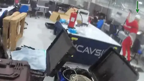 Identan funcule funcule Bbc The officer is on the floor to the left, called by the factory employee.