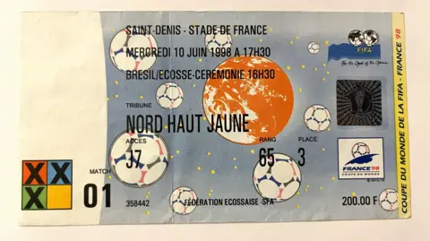 Kevyn Whitelaw Esta imagen muestra una entrada para la Copa Mundial de la FIFA 1998 celebrada en Francia. Es para el partido inaugural entre Brasil y Escocia en el Stade de France, Saint-Denis, el miércoles 10 de junio de 1998, a las 17:30 horas.